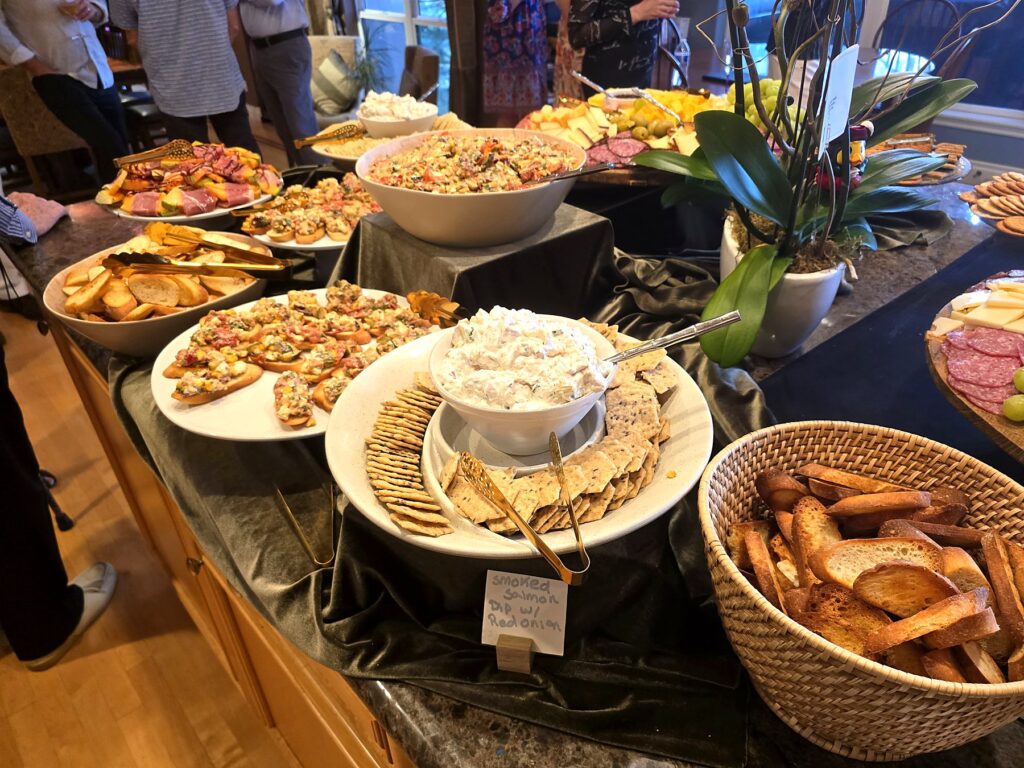 Appetizer buffet at a private party — smoked salmon dip, bruschetta, charcuterie and cheese
