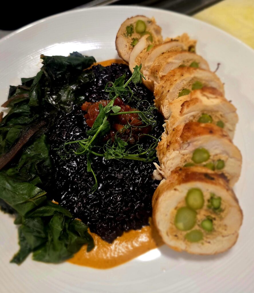 Sliced stuffed chicken roulade with asparagus, black rice, braised rainbow chard and chutney on a private chef dinner plate